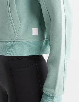 Close up of a green sweater and black leggings.