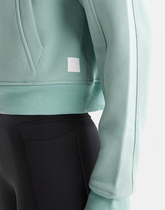 Close up of a green sweater and black leggings.