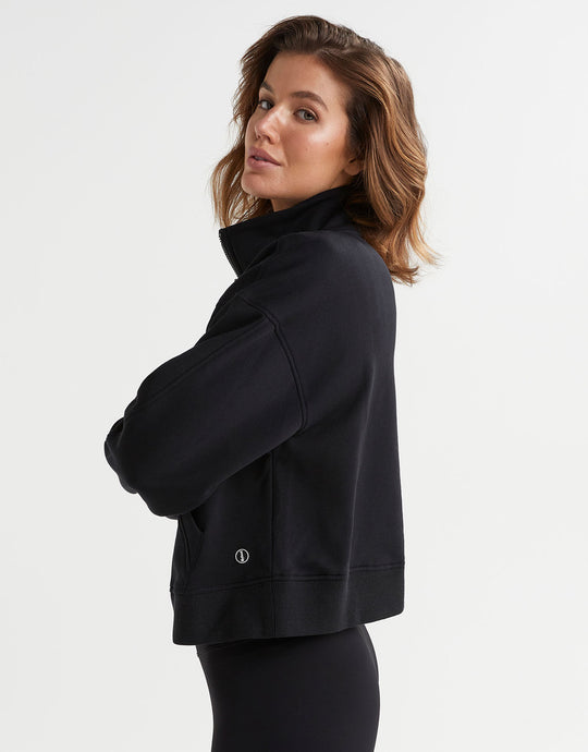 Side view of a woman wearing a black sweater and leggings