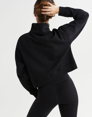 Rear view of a woman wearing a black sweater and leggings