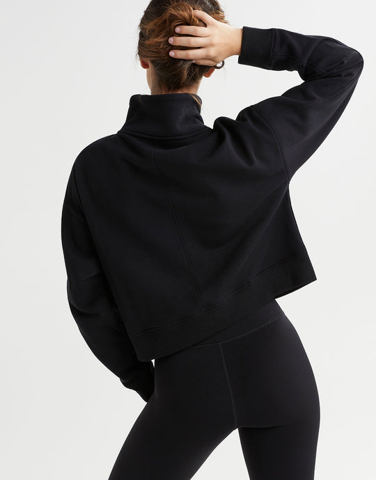 Rear view of a woman wearing a black sweater and leggings