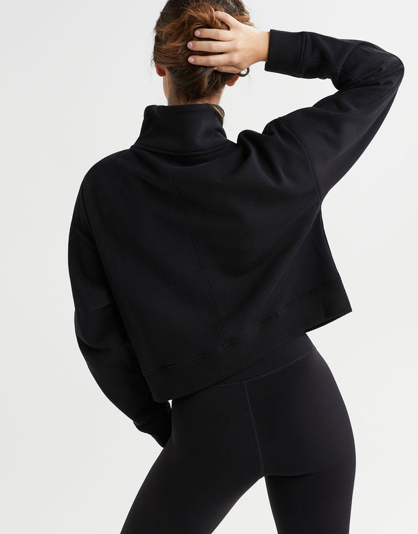 Rear view of a woman wearing a black sweater and leggings