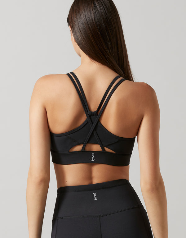 Person wearing a black sports bra and leggings on a plain background