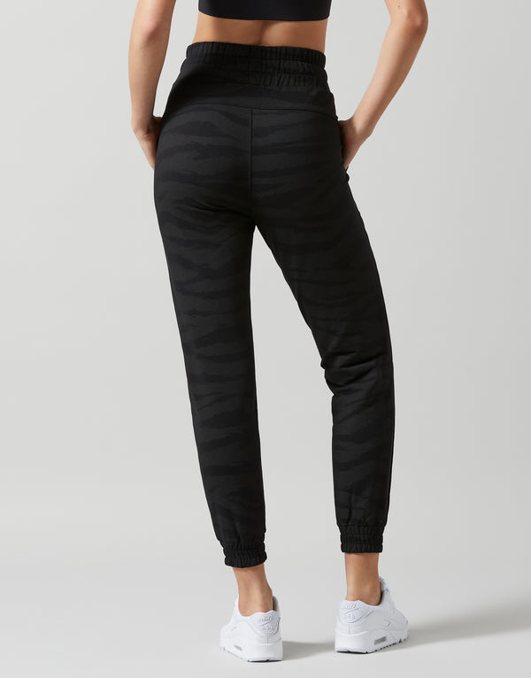 Person wearing black Lilybod Rylee jogger pants on a gray background
