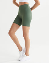 Green athletic shorts worn by a person on a white background