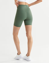 Green athletic shorts worn by a model on a white background