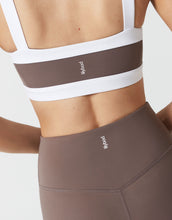 Close up of a brown and white sports bra and brown leggings