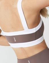 Close up of a sports bra in brown and white with a logo
