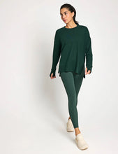 Woman wearing a green activewear outfit on a white background