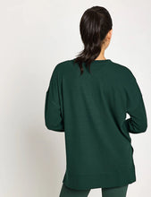 Woman wearing a green sweater on a white background