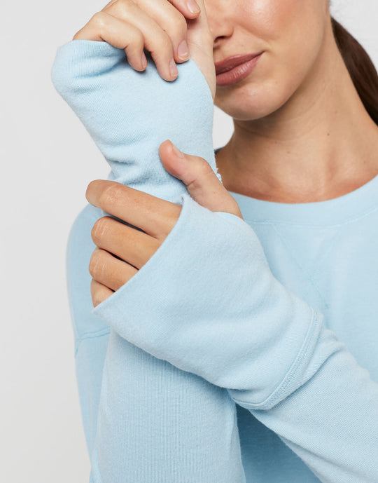 Person wearing a light blue sweatshirt against a plain background