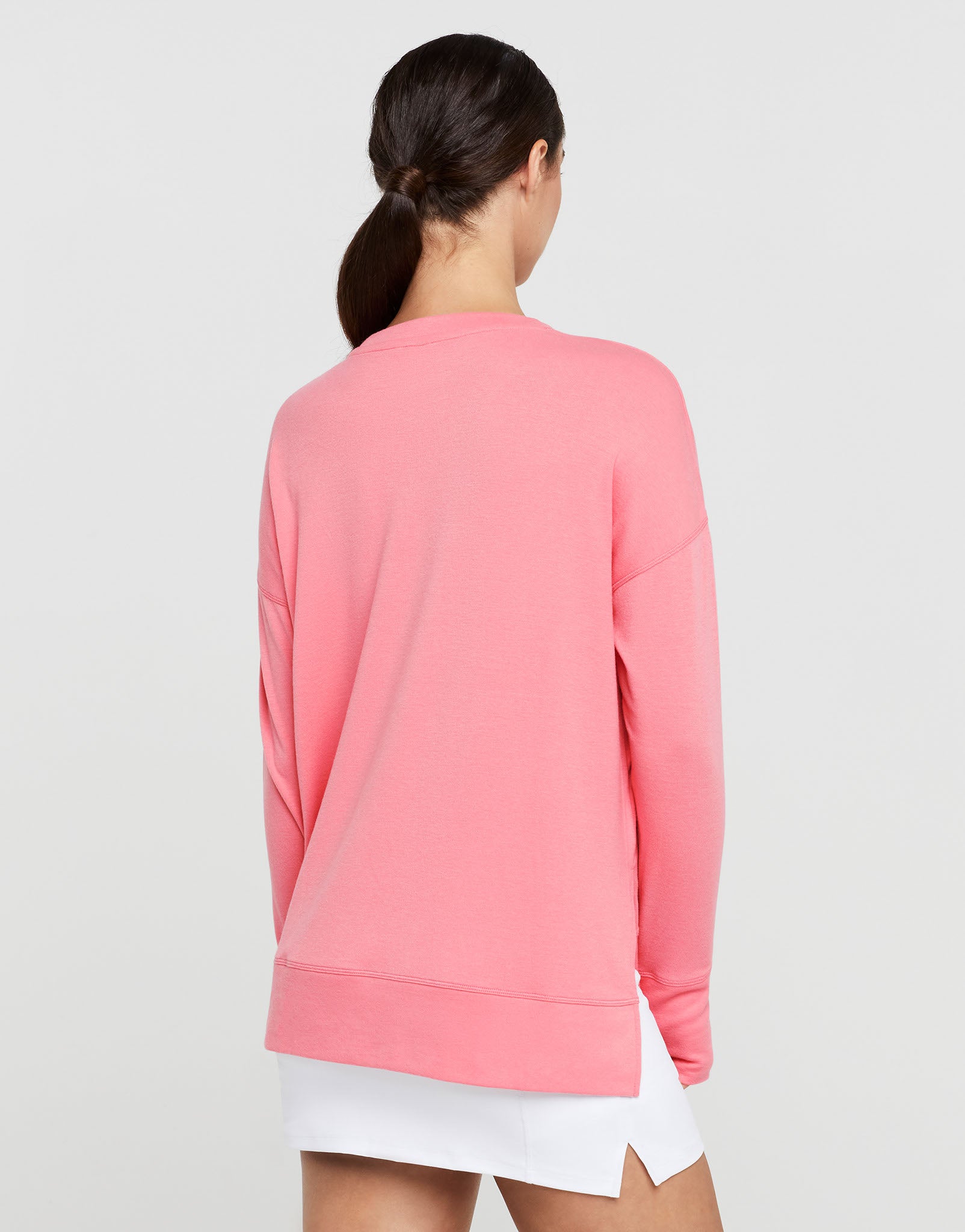 Person wearing a pink sweatshirt on a light gray background