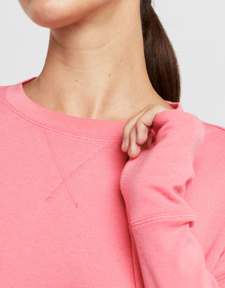 Close-up of a person wearing a pink sweatshirt with a blurred background