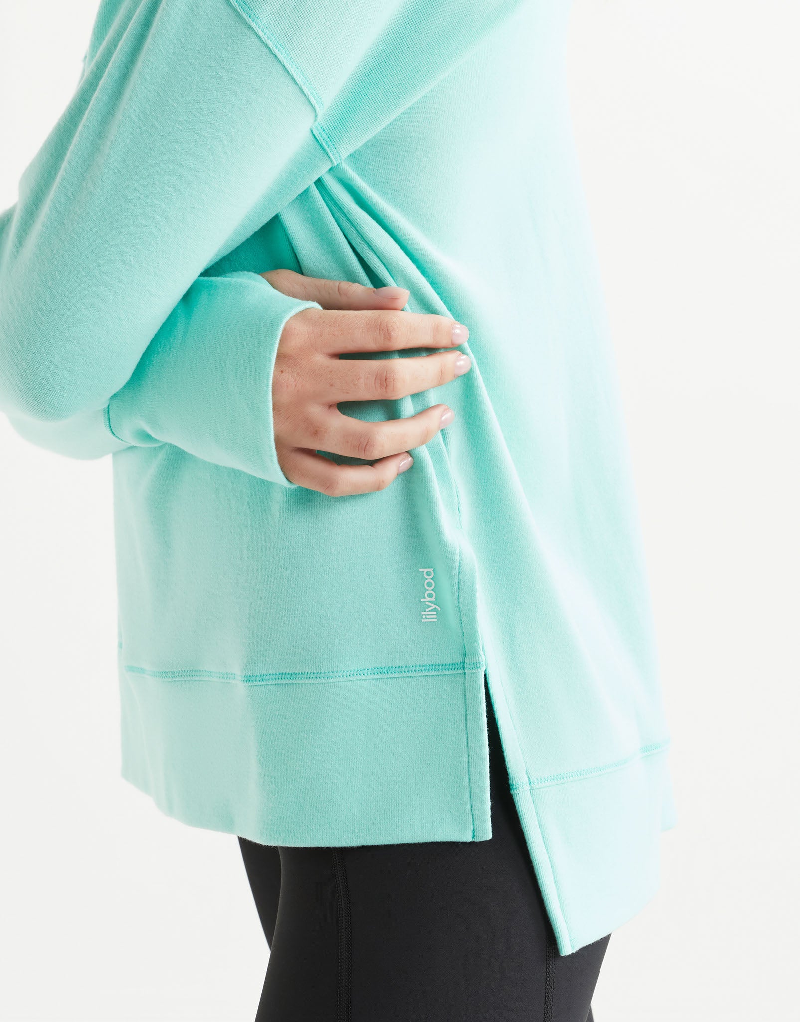 Person wearing a light blue jacket with a brand logo on a white background
