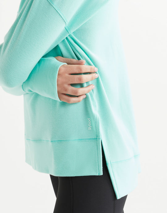 Person wearing a light blue jacket with a brand logo on a white background