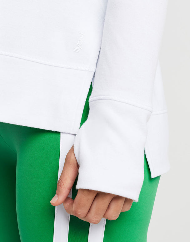 Close up of green athletic shorts and  white long sleeved top