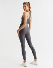 Woman wearing a gray athletic outfit on a white background