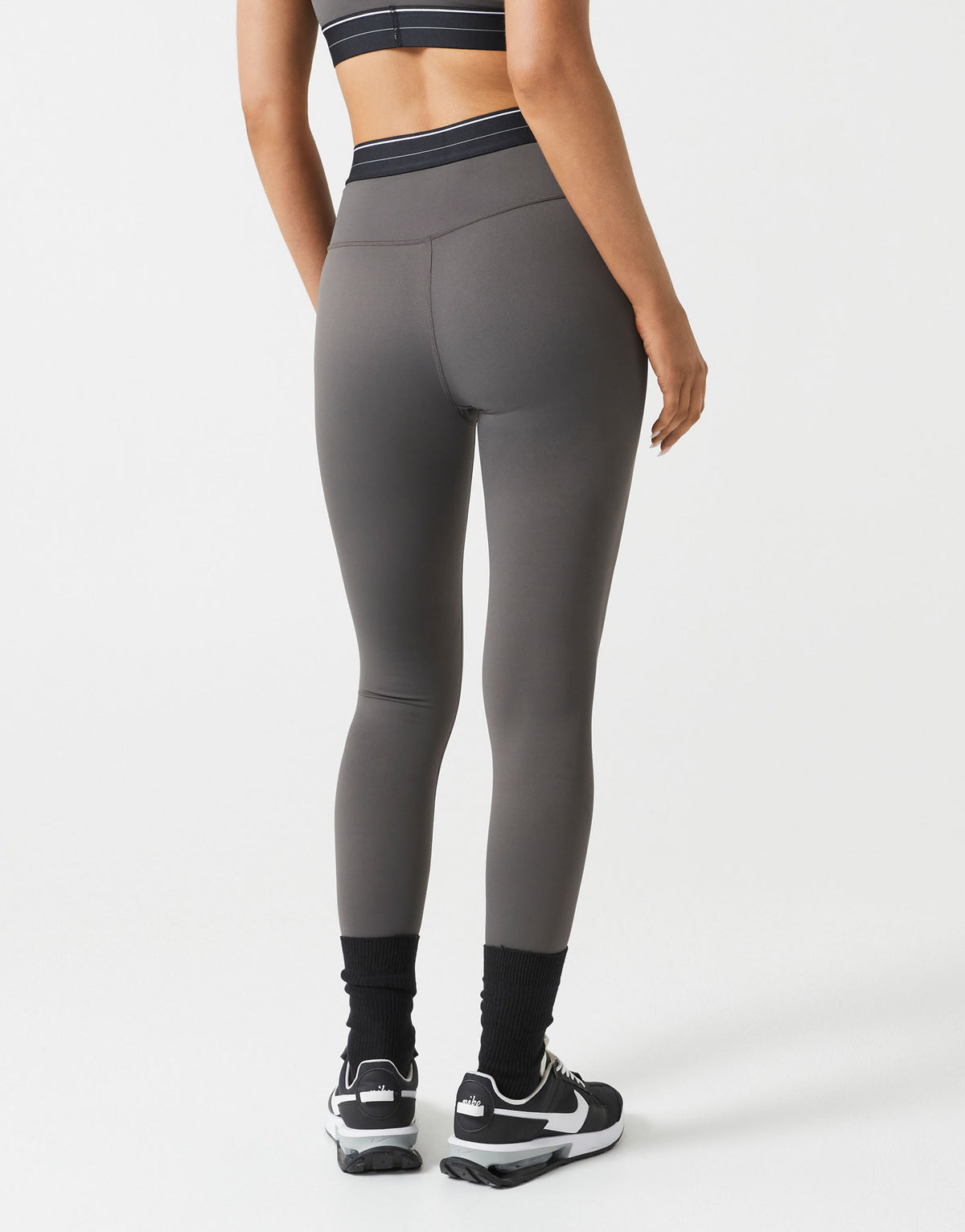 Person wearing gray leggings on a white background