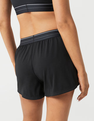 Black athletic shorts worn by a person on a light gray background