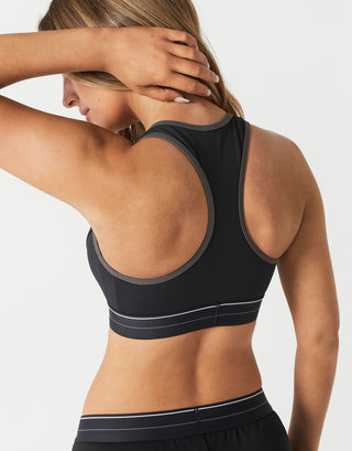 A model wearing a black sports bra and black pants from the back.