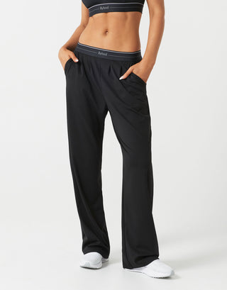 A model wearing black sweatpants and white runners