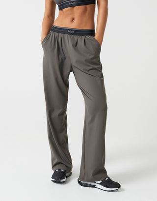 A person wearing olive green wide leg pants on a white background.