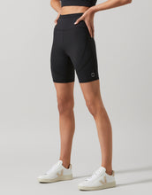 Person wearing black athletic shorts on a light gray background