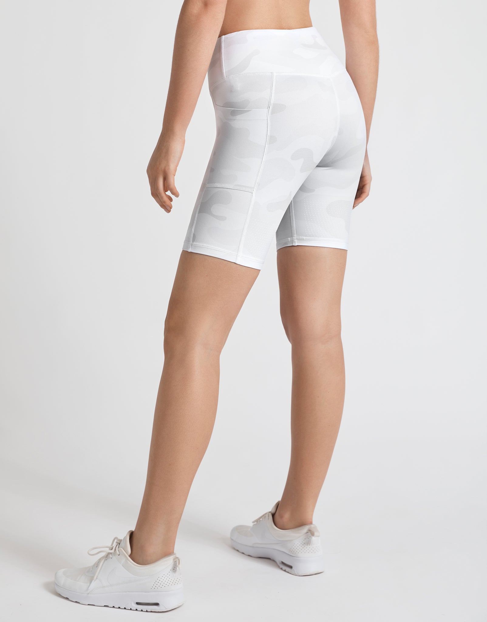A pair of whispers tan camo bike shorts with back outer leg pockets, designed for high-waist fit and workouts.