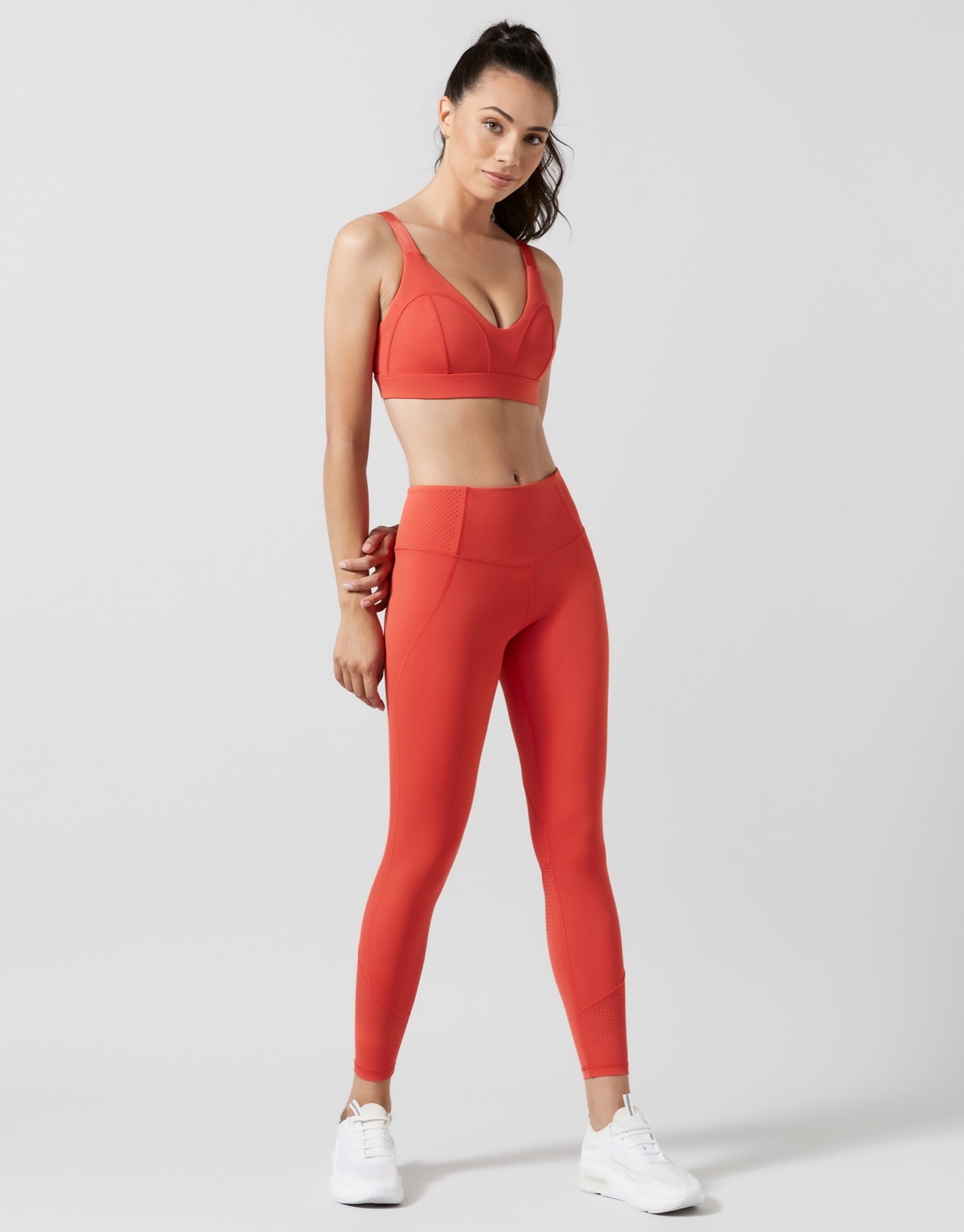 Woman wearing a red athletic outfit on a white background