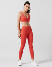 Woman wearing a red athletic outfit on a white background