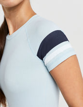 Light blue t-shirt with dark blue and white sleeve details on a plain background