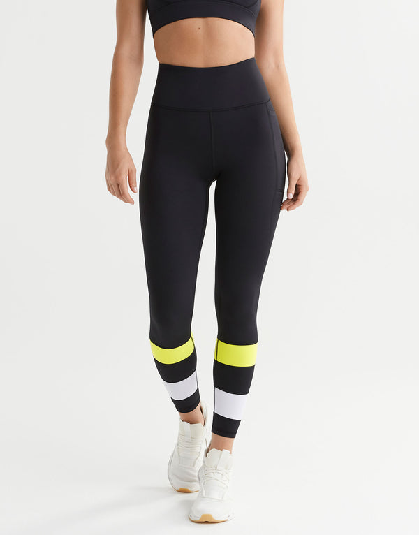 Black leggings with colorful stripes worn by a person on a white background