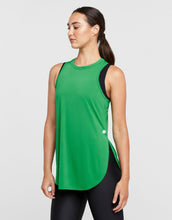 Woman wearing a green sleeveless top with black accents on a light gray background