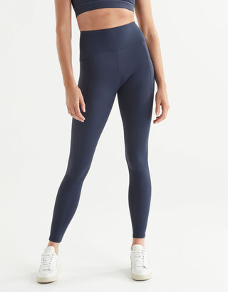 Person wearing navy blue leggings on a white background