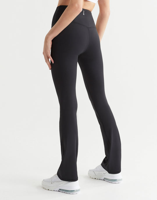 A model in a pair of high-waisted black bootcut leggings, shown from the waist down with a focus on the fit and design of the leggings.