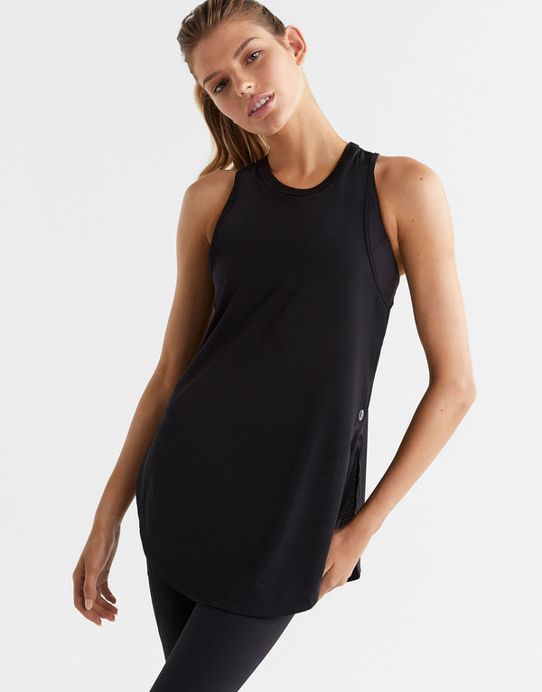 Woman wearing a black sleeveless top on a white background