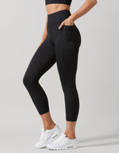 Person wearing black leggings and white sneakers on a light gray background