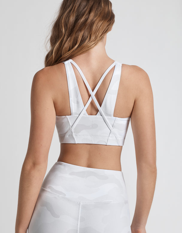 White sports bra with criss-cross back design on a plain background