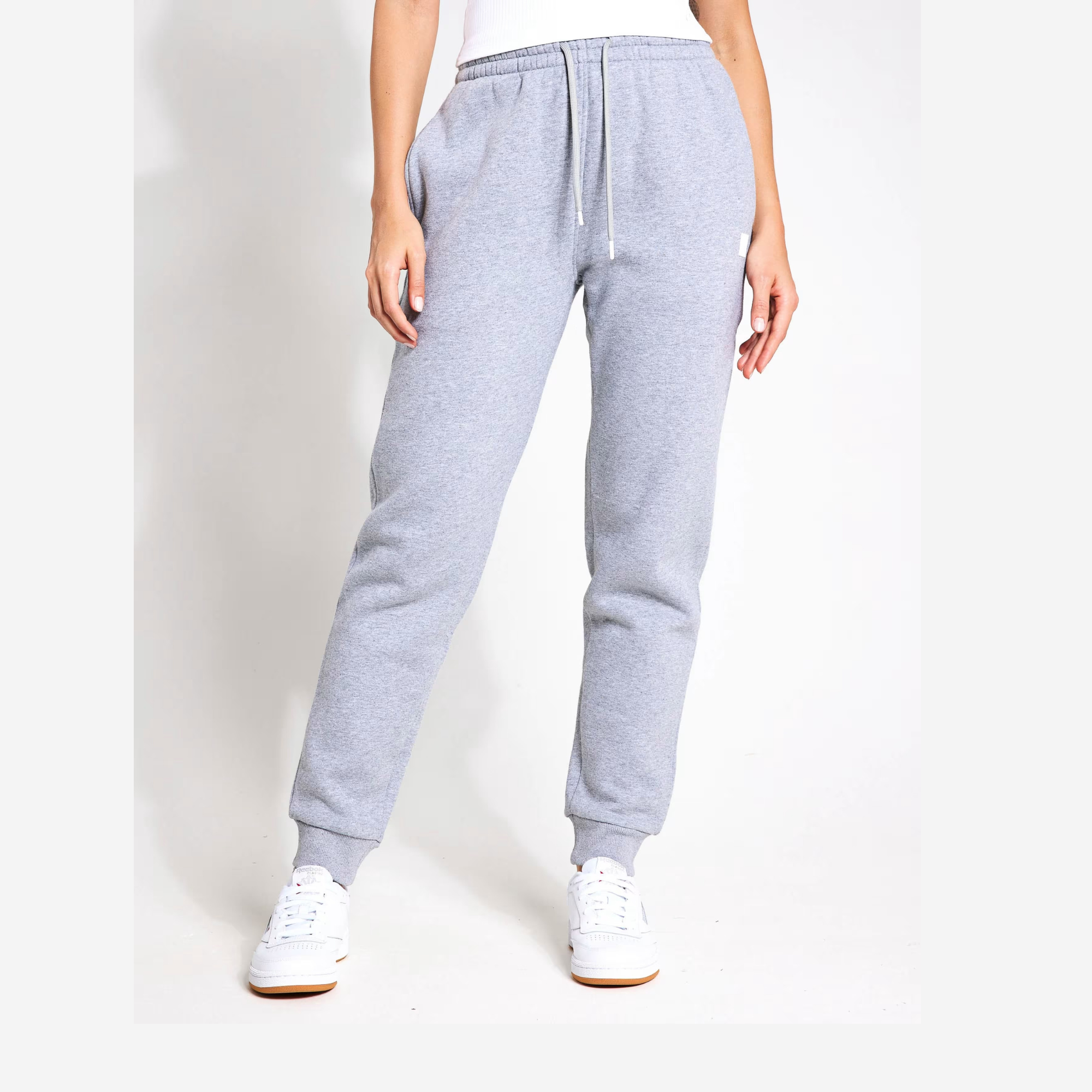 Grey sweatpants worn by a person on a white background