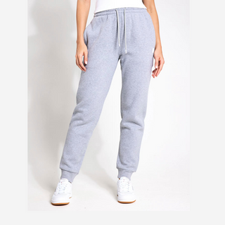 Grey sweatpants worn by a person on a white background