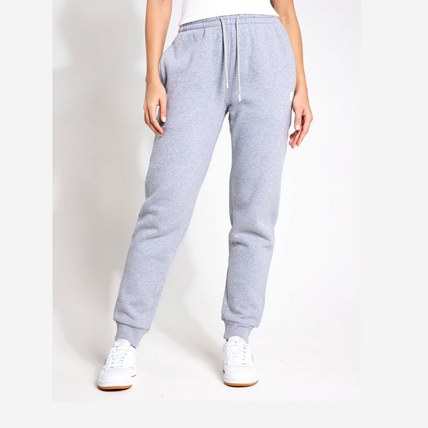 Grey sweatpants worn by a person on a white background