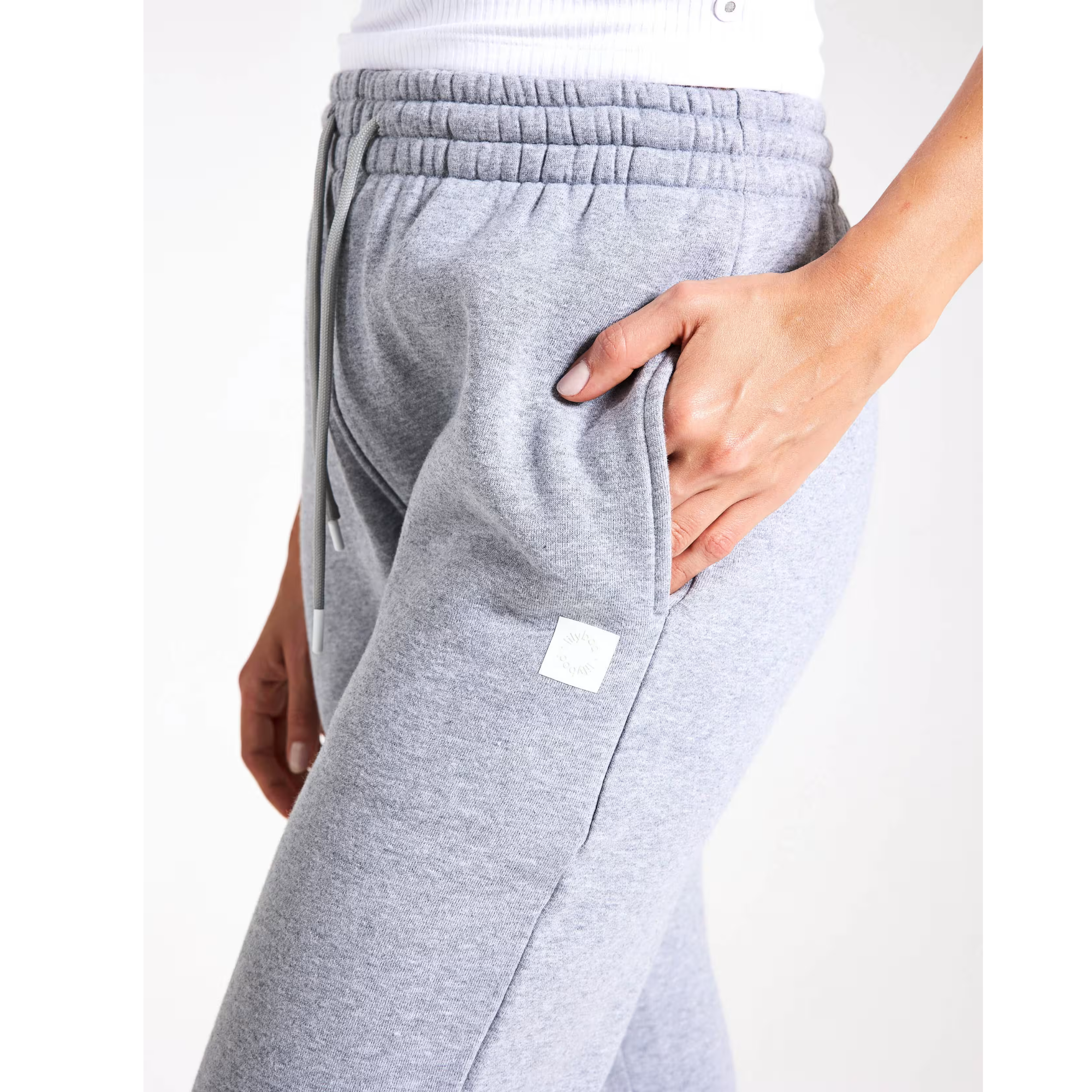 Grey sweatpants with a small white logo on a white background