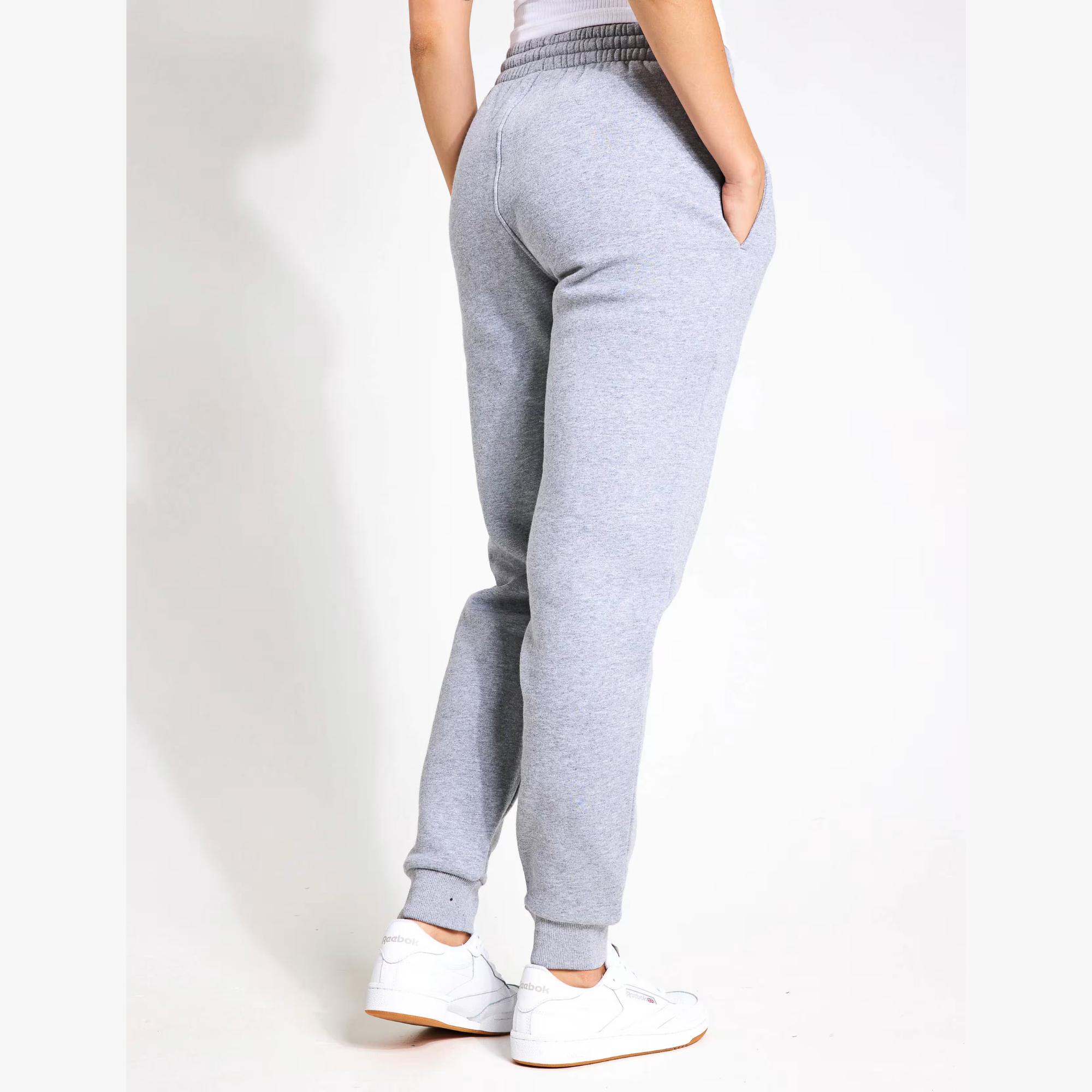 Grey sweatpants worn by a person on a white background