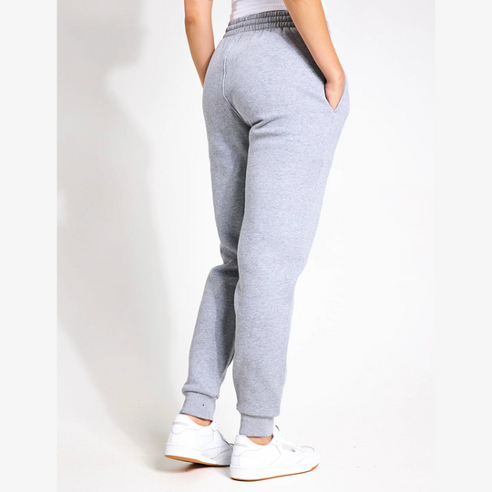 Grey sweatpants worn by a person on a white background