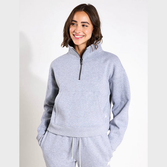 Woman wearing a grey tracksuit on a white background