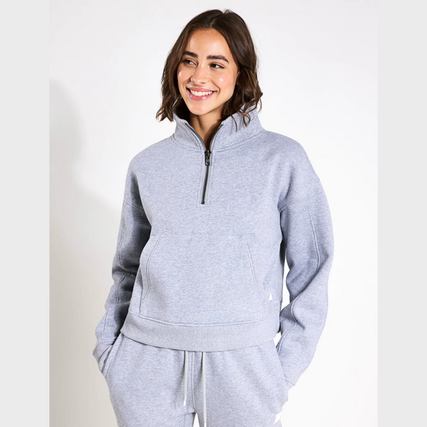 Woman wearing a grey tracksuit on a white background