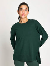 Woman wearing a green sweater against a white background